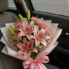 A graceful bouquet of pink lilies and blush roses, wrapped in beautiful