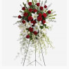 Red roses, white lilies and cascading white orchids are elegant funeral flowers
