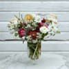 A lovely red and white arrangement of roses, astrantia, double tulips, and