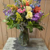A colorful assortment of summer blooms- blue delphinium, lisianthus, roses, gerbera daisies