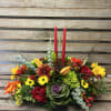 Designers choice of fall flowers, arranged in a Long and low centerpiece