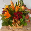 A warm autumn centerpiece designed in a woven basket, featuring orange lilies
