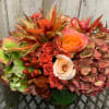 Amaryllis emerge from antique hydrangea, accented by free spirit and peach roses.