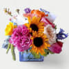 Bursting with fresh seasonal blooms in vibrant colors. This cheerful bouquet is