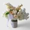 Beautiful white blossoms roses orchids hydrangeas and more arranged in a tall