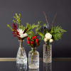 Three gorgeous cut glass bud vases filled with a mix of white