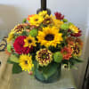  A beautiful arrangement with assorted fall flowers  in a glass