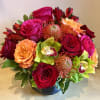 Beautiful warm vibrant hues of roses &amp; pin cushion protea against lime