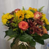 A radiant mix of golden yellow chrysanthemums, fiery orange roses, rustic bronze
