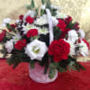 A festive holiday cheer basket full of greens, flowers, pine cones and