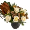 White roses, Christmas greens &amp; Christmas decor arranged in a glass vase.