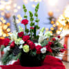 This festive floral arrangement features a stunning combination of vibrant red, soft