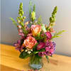 This elegant vase features a beautiful arrangement of pink and purple flowers