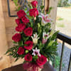 This is a tall flower basket with roses and lilies that you