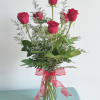 Six exquisite red roses arranged with tropical foliage in a clear bud