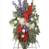 A patriotic floral arrangement in red, white, and blue, symbolizing honor and