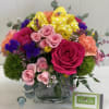 Bright beautiful assortment of spring flowers in a glass cube