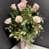 A dozen premium Pink roses, accented with seasonal greenery and arranged in