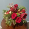 Winterpine, red roses and poinsettas in a ceramic container