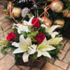 White lilies, red roses, pine and other holiday accents. Perfect for anyone