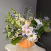 A beautiful floral arrangement with seasonal fresh flowers in a vase. 