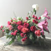A captivating blend of seasonal beauty with roses, lilies, and festive cheer
