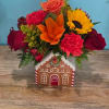 A beautiful arrangement designed in a ceramic gingerbread house. Perfect to decorate