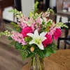Pink snapdragons, hot pink roses and white lilies create a lovely arrangement