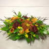 A traditional centerpiece featuring a fall mix of carnations, chrysanthemums, greens, and