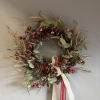 A wonderful small holiday wreath, decorated with pine, silk berries and fake