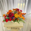 Chrysanthemums, carnations, wheat, gourds, and more are gathered in a low container