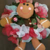 This cute 24&quot; silk wreath dressed as a yummy gingerbread girl, is