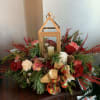 This unique centerpiece displays a beautiful gold lantern surrounded by the freshest