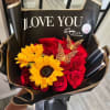 A daring combination of radiant sunflowers and passionate red roses, wrapped in