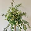 A tall fragrant holiday flower arrangement with lots of wintergreens, eucalyptus, white
