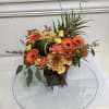 A warm welcome for fall, this arrangement features a variety of orange