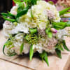 A chic bridal bouquet of white flowers arranged in a round shape.
