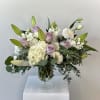This bouquet consists of white lilies, white lisianthus, purple roses, white hydrangea