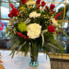 Bursting with holiday color this arrangement features white hydrangeas, and mums. Layered