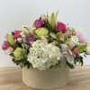 A beautiful combination of hydrangea, rose, lily, and cymbidium orchid in soft