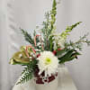 A festive mix of white snapdragons, white cremone, magnolia leaves, snowy accents