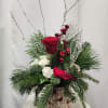 A festive blend of a red rose, white mini carnations, red berries