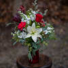 Pretty white lily and red roses with carnations nested on bountiful winter