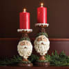 Hand-painted poly-resin pedestal candleholders in two heights. Old Fashion Santa face as