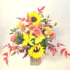 A beautiful bronze colored vase filled with sunflowers,roses,carnations and lilies with glittering