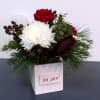 In a festive container with beautiful holiday colored blooms and greens, Oh