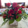 Available for Delivery starting 11/28/2025 This trio of red roses is surrounded