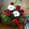 A beautiful red and white arrangement with candy canes and Christmas greens.