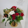 a red and white Christmas arrangement in a gold vase perfect for