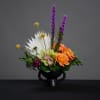 Unique, contemporary compote with orange roses, cymbidium orchid, liatris, green trick dianthus